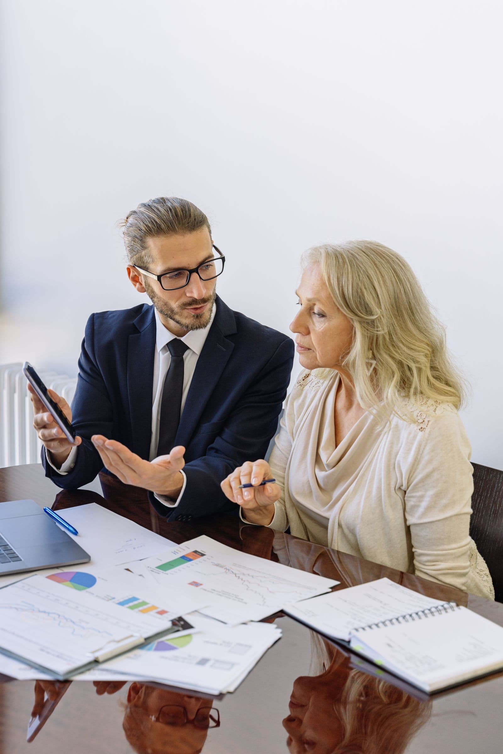 An advisor reviewing account details on a phone with a client